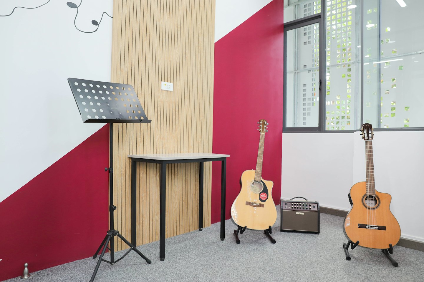 Two acoustic guitars stand inside a modern music studio.
